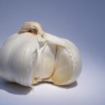 Aglio fresco su un tagliere, simbolo dei benefici per fegato e digestione.